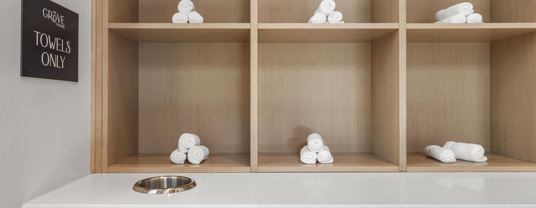 a shelf with white towels animals on it
